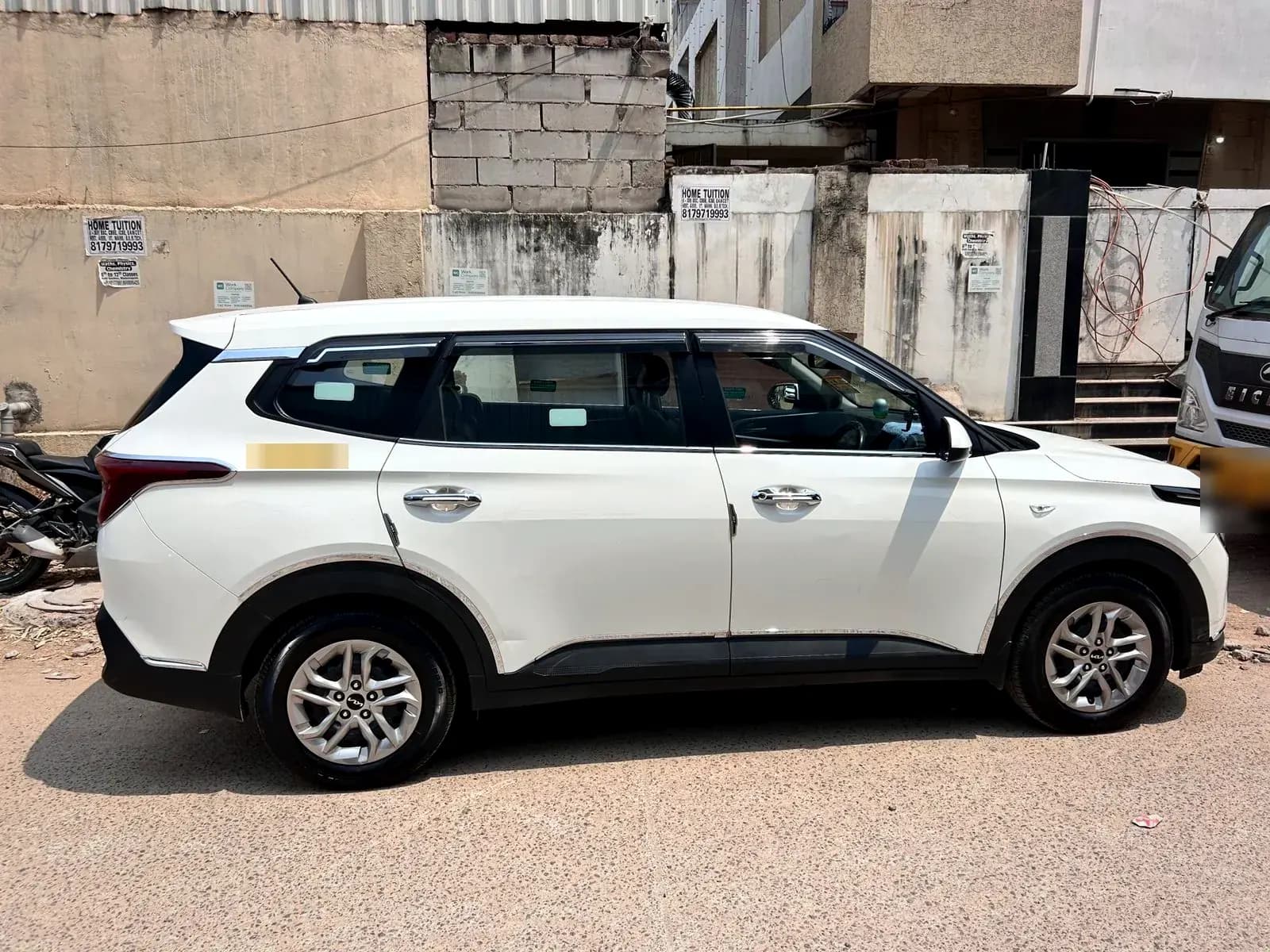 White Kia Carens — side profile